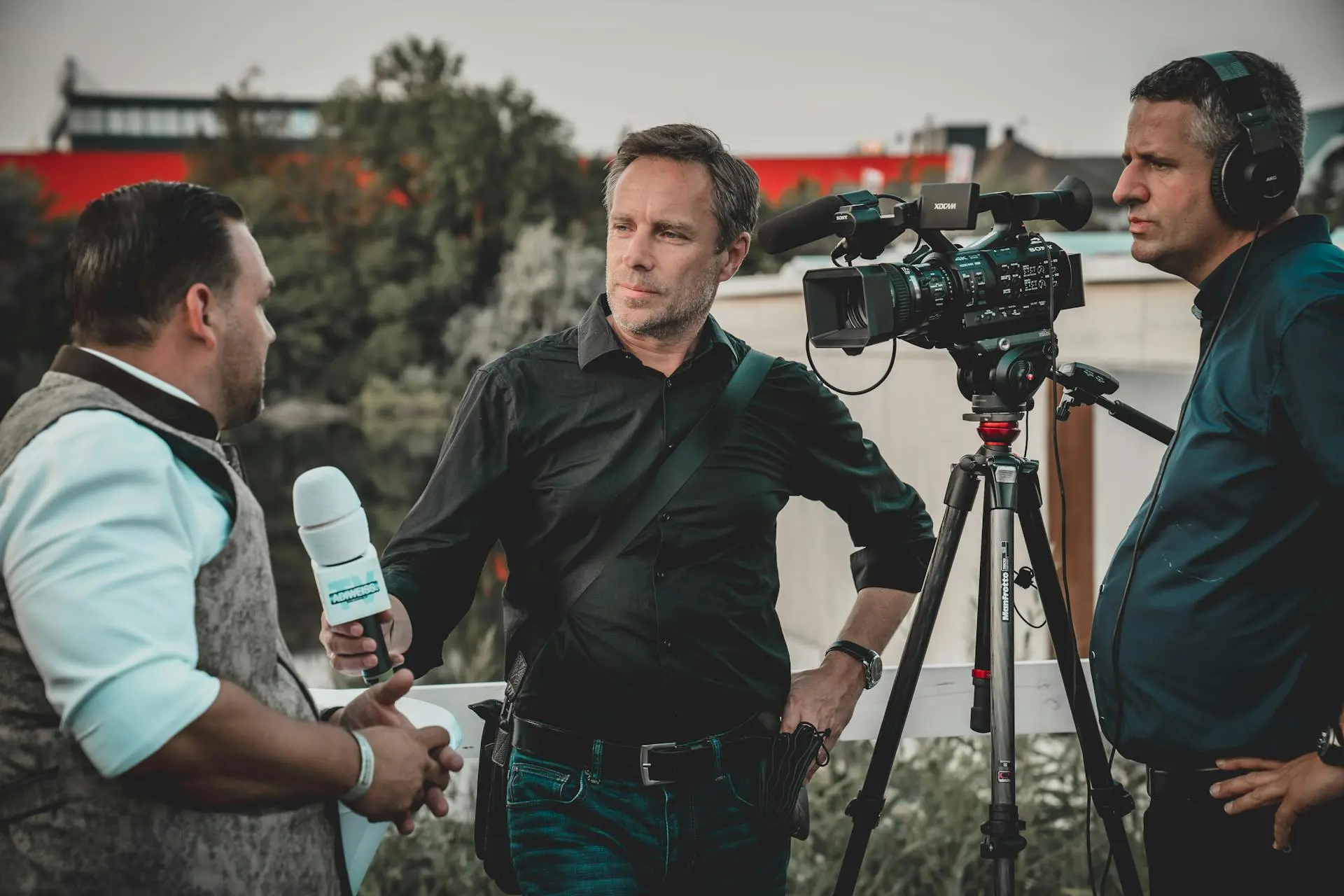 Man Holding Microphone While Talking to Another Man
and covering a story