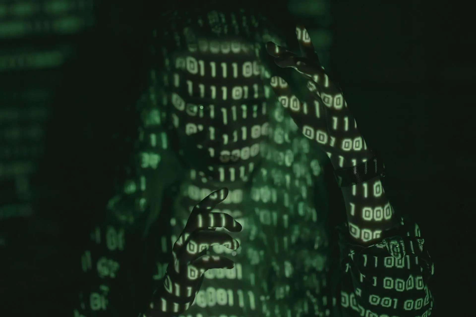 An unrecognizable person with binary code projected, symbolizing cybersecurity and digital coding
